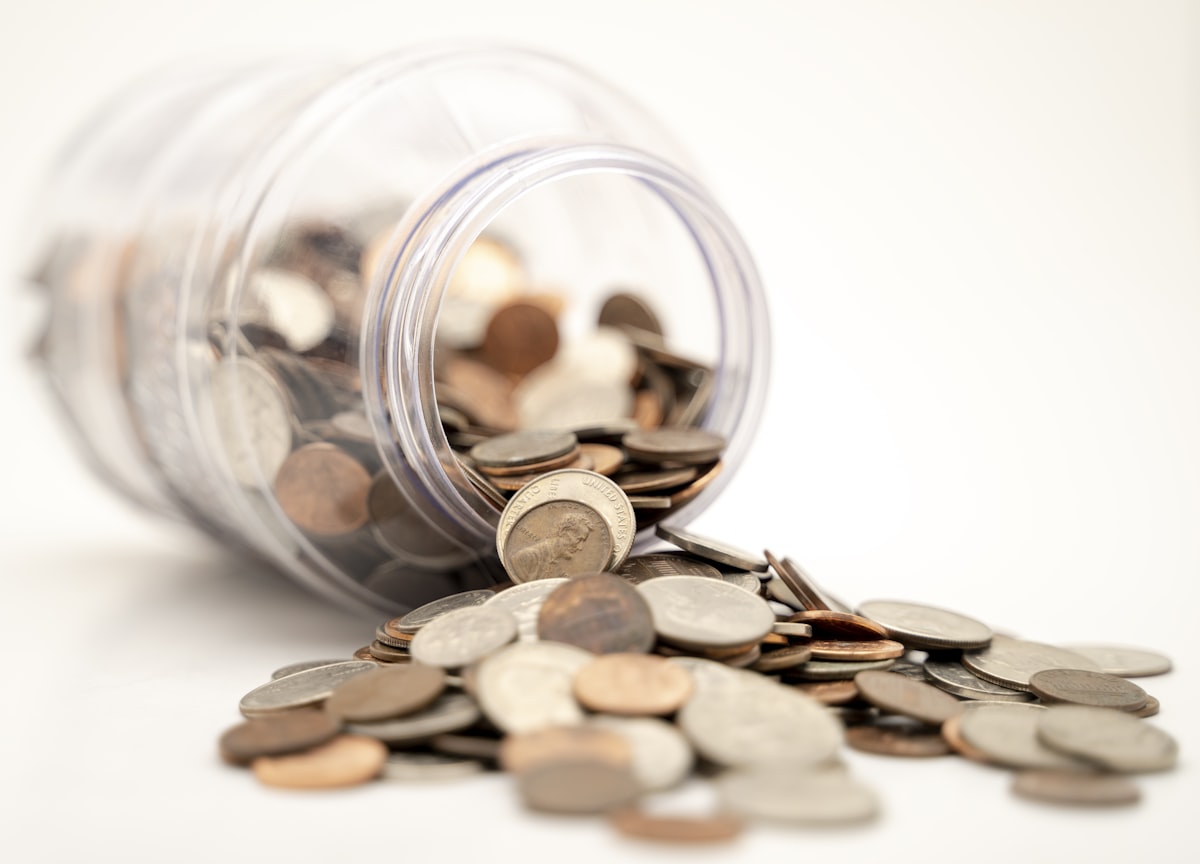 Coins spilling from a glass savings jar