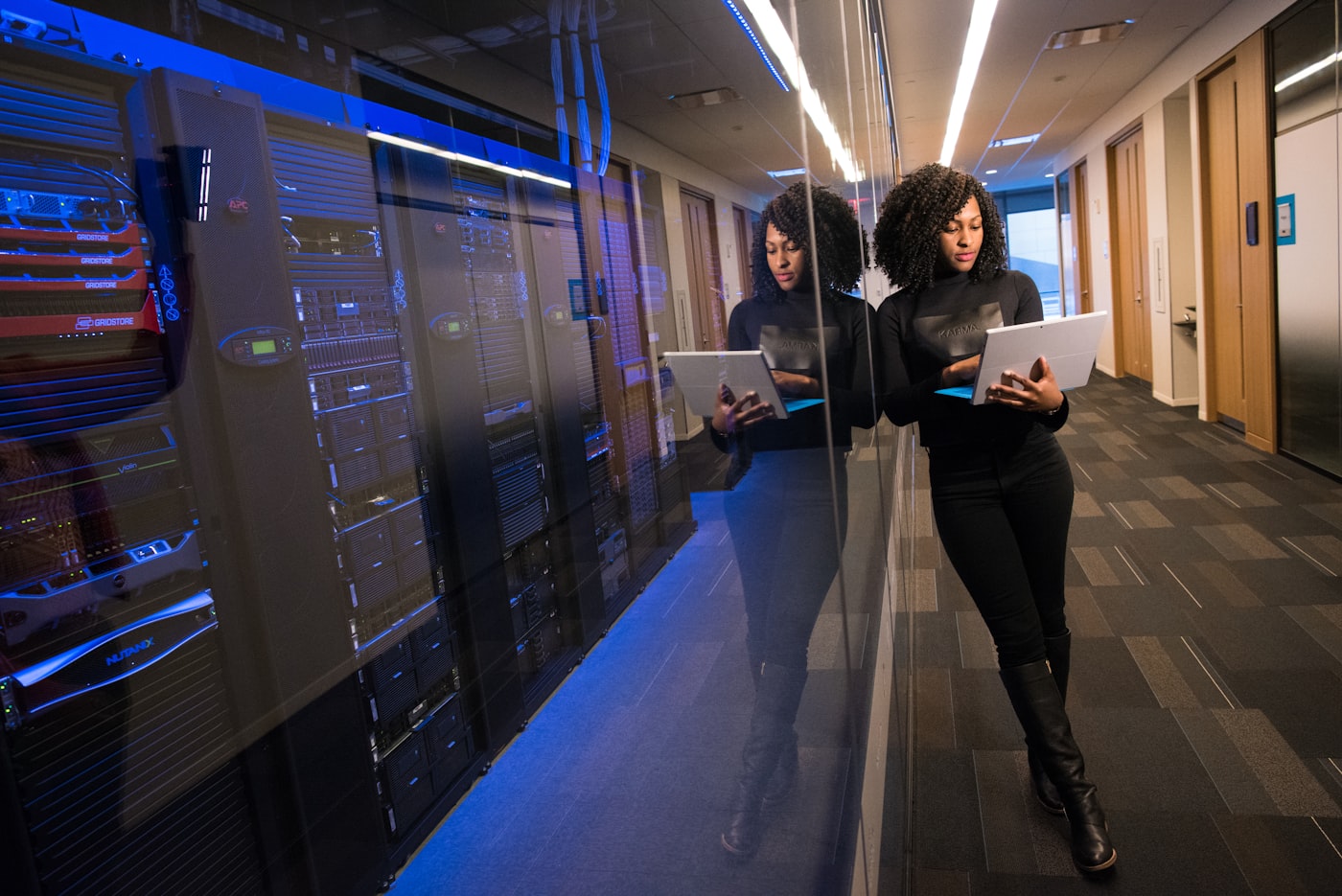 Two colleagues walking through a corridor reviewing tablets