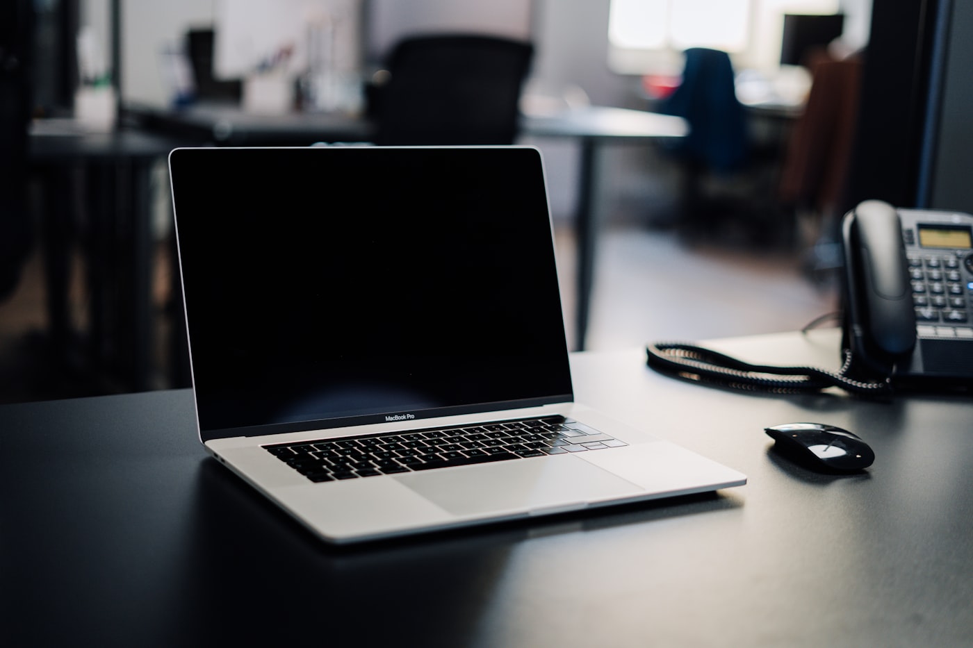 A laptop and desk phone on a clean workspace