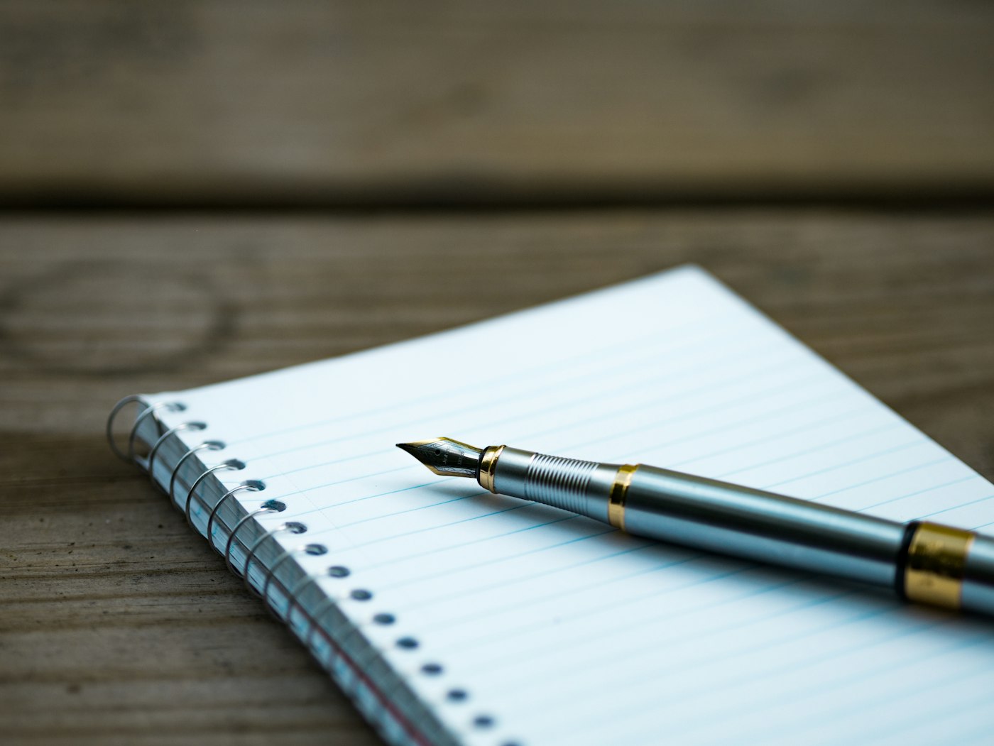A notebook and fountain pen on a desk
