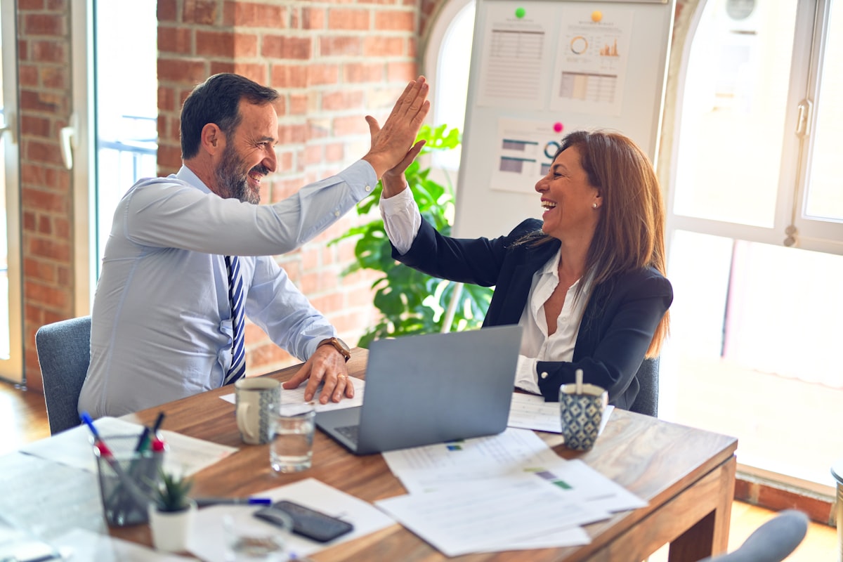 Two colleagues celebrating a result in an office